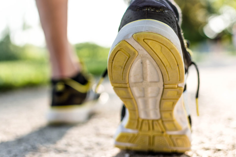 Close up of a men's running shoe treads on a sidewalk.